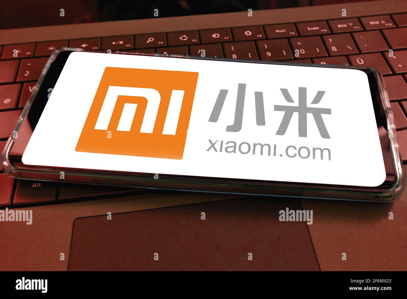 Primo piano dello schermo dello smartphone con il logo di xiaomi cinesi società di telefonia mobile con sfondo tastiera per computer Foto Stock