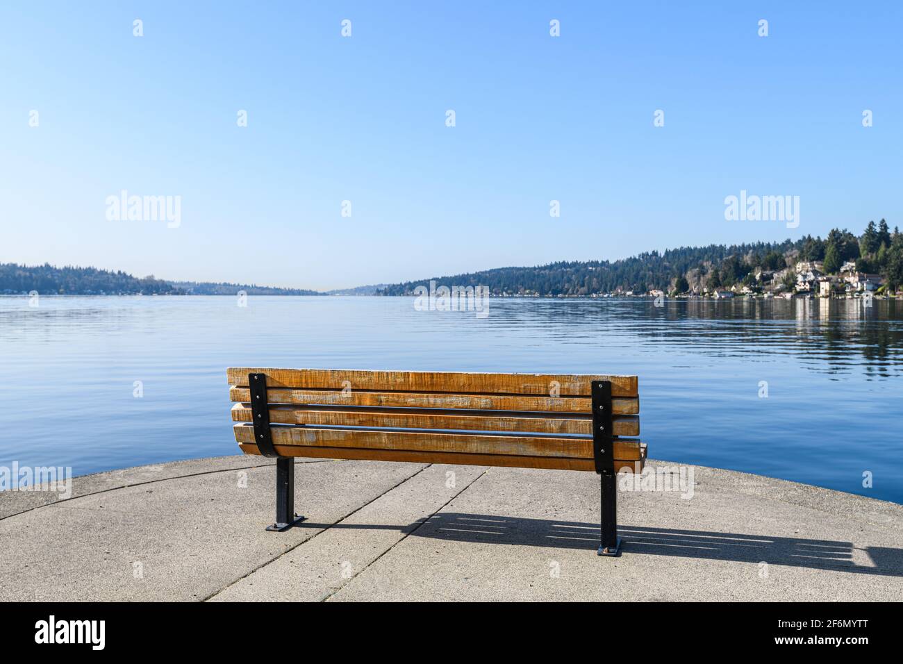 Una panchina sul bordo del lago Washington su un perfetto cielo blu mattina crea una sensazione di solitudine e. solitudine come guarda fuori su niente Foto Stock