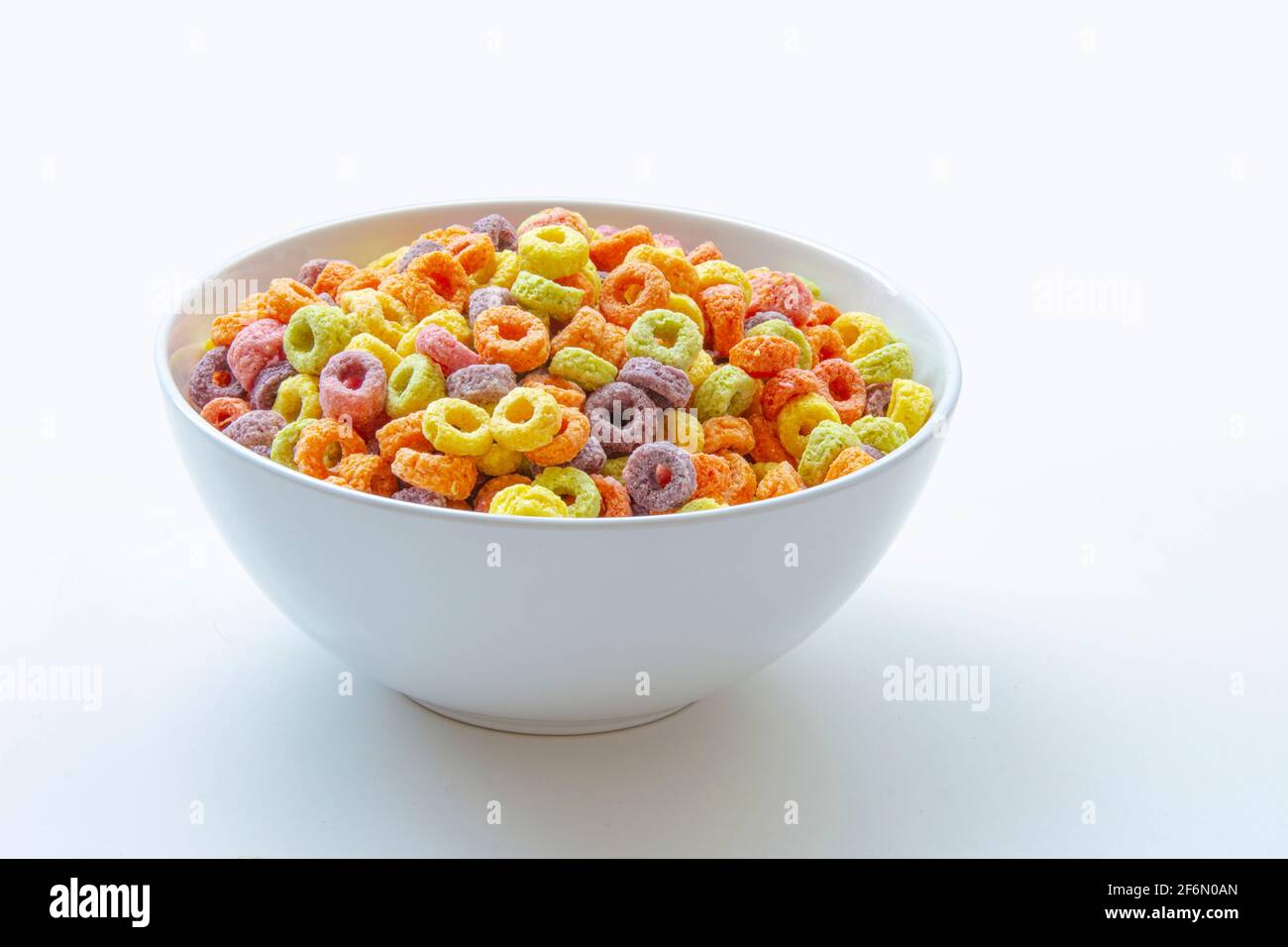 Cereali dolcificati aromatizzati alla frutta a forma di anello su una varietà di colori brillanti e una miscela di sapori di frutta. Rosso, arancione, giallo, verde, blu e viola ri Foto Stock