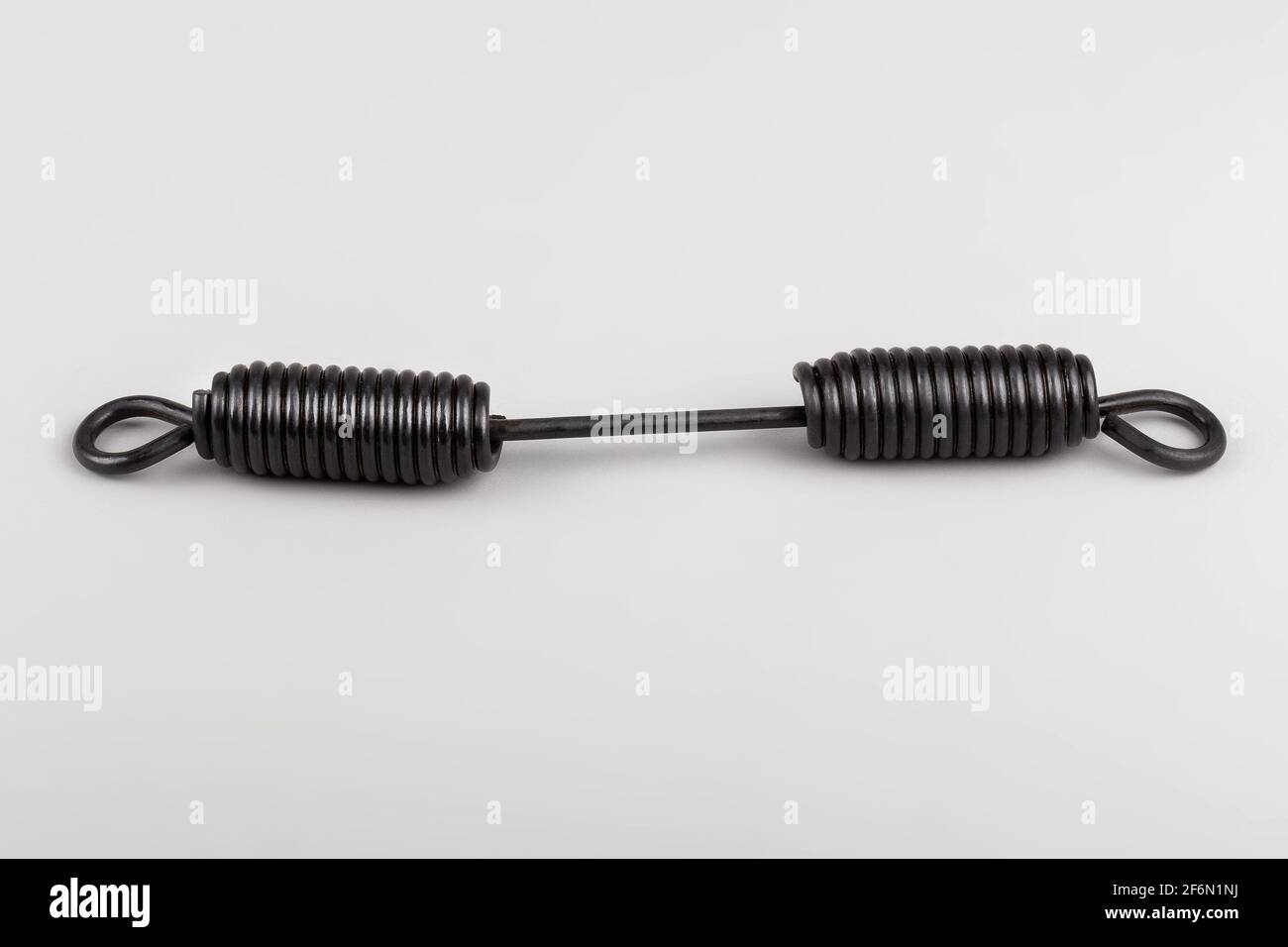molla delle pastiglie dei freni del carrello. Molla delle pastiglie dei freni su sfondo grigio. Molla. Molla di richiamo Foto Stock