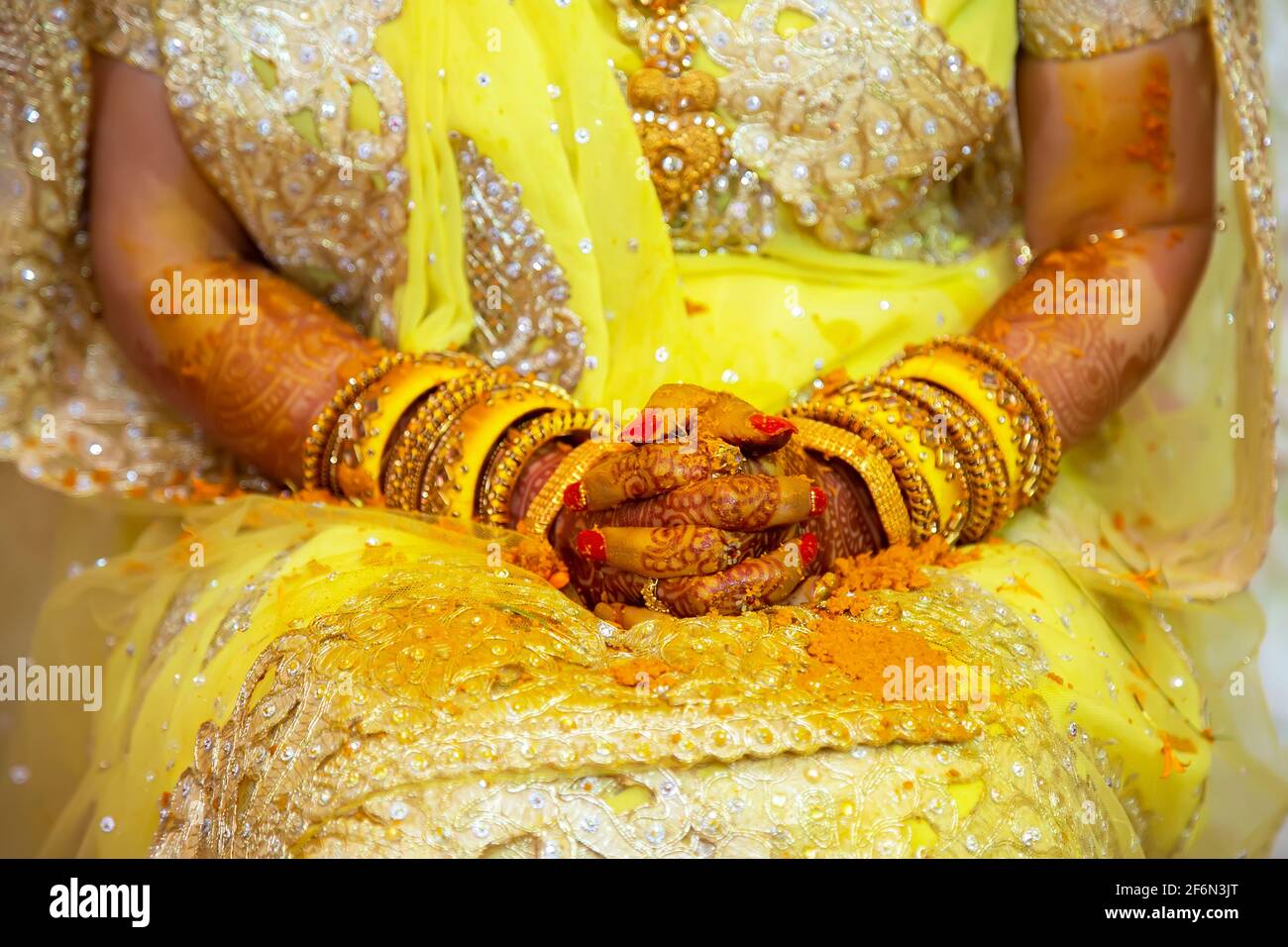 La mano della sposa indù dipinta con pasta curcuma fresca alla sua vigilia di nozze. Foto Stock