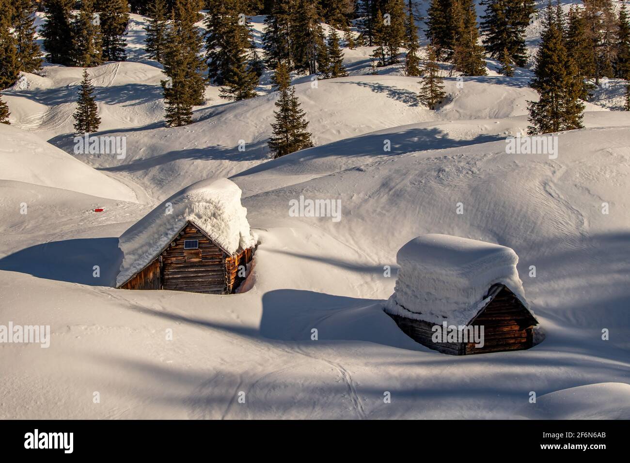 Due capanne di montagna coperte di strati di neve Foto Stock