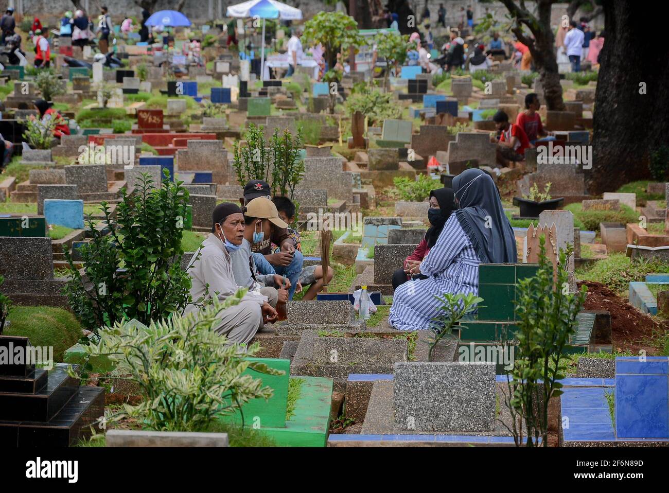 I residenti pregano nelle tombe dei loro parenti al Karet Bivak Public Cemetery (TPU), Giacarta, Indonesia, venerdì 2 aprile, 2021. Anche se il DKI Foto Stock