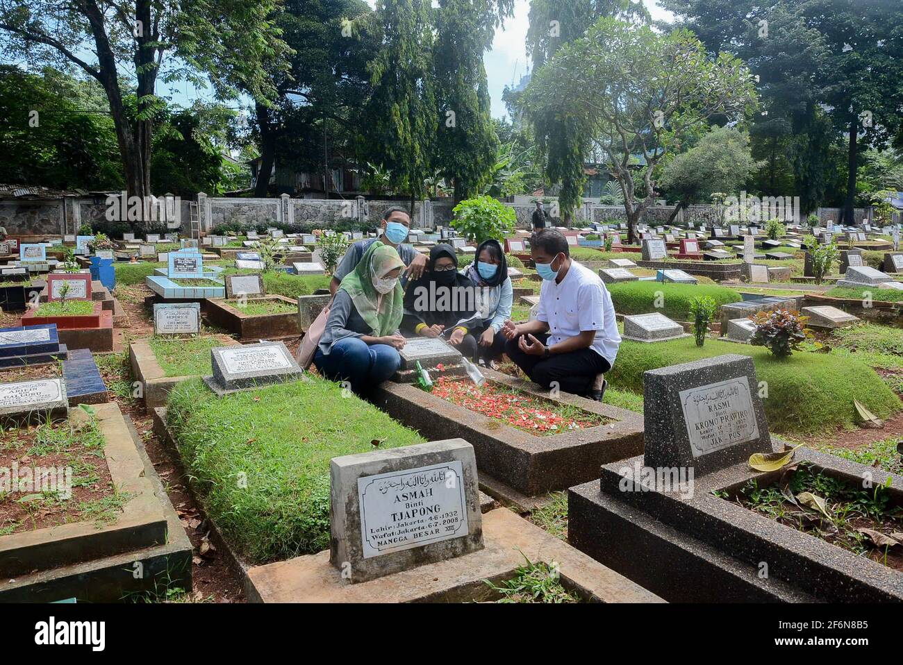 I residenti pregano nelle tombe dei loro parenti al Karet Bivak Public Cemetery (TPU), Giacarta, Indonesia, venerdì 2 aprile, 2021. Anche se il DKI Foto Stock
