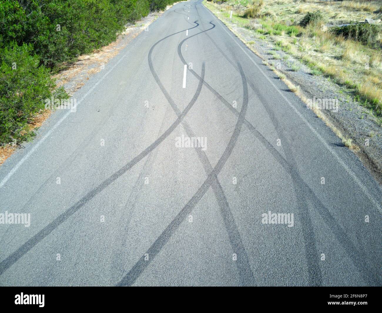 La macchina slitte segna la vista aerea sulla strada asfaltata con campo erba, Victoria, Australia. Foto Stock