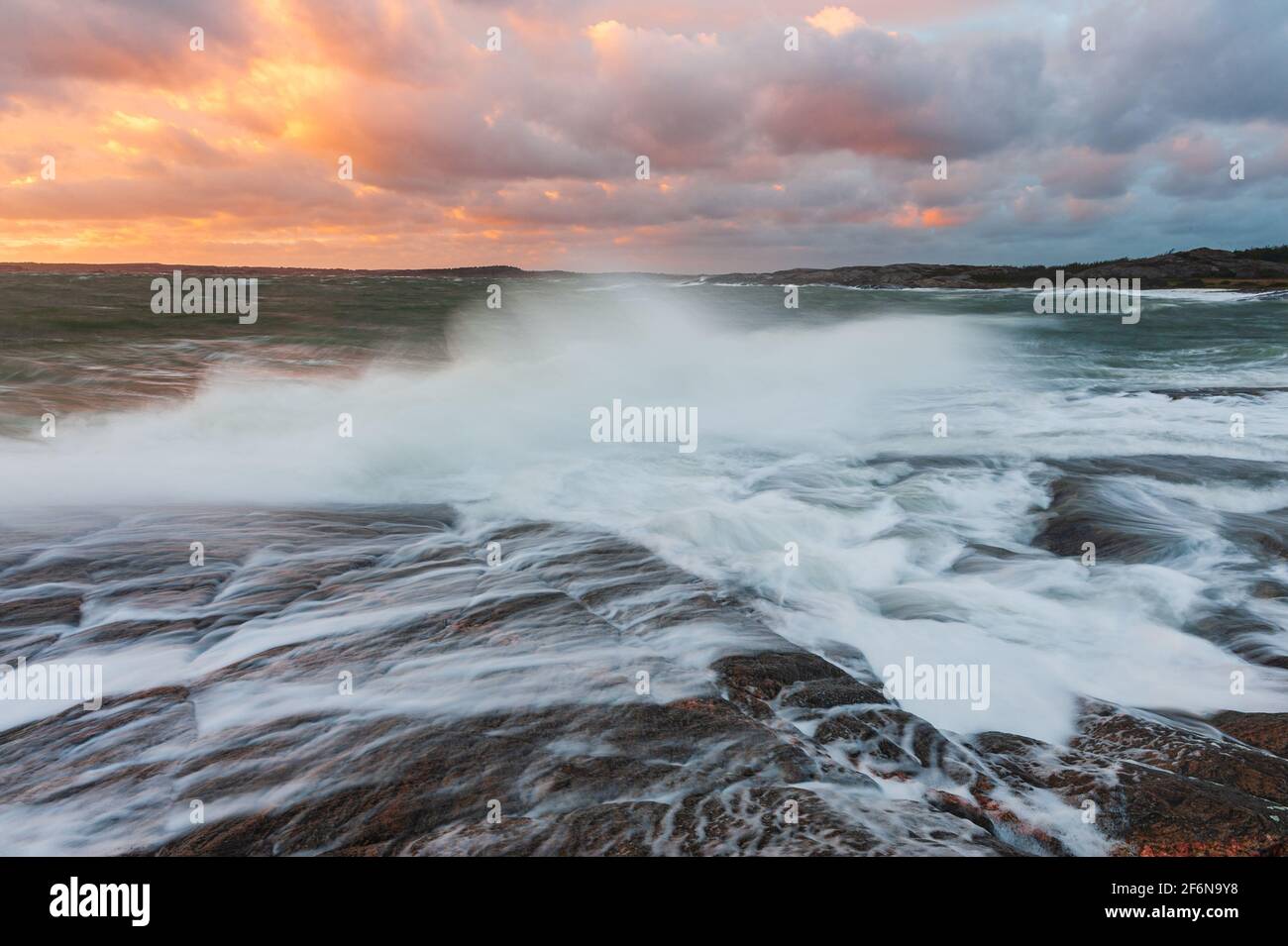 Onde che si infrangono sulla spiaggia al tramonto, Svezia Foto Stock