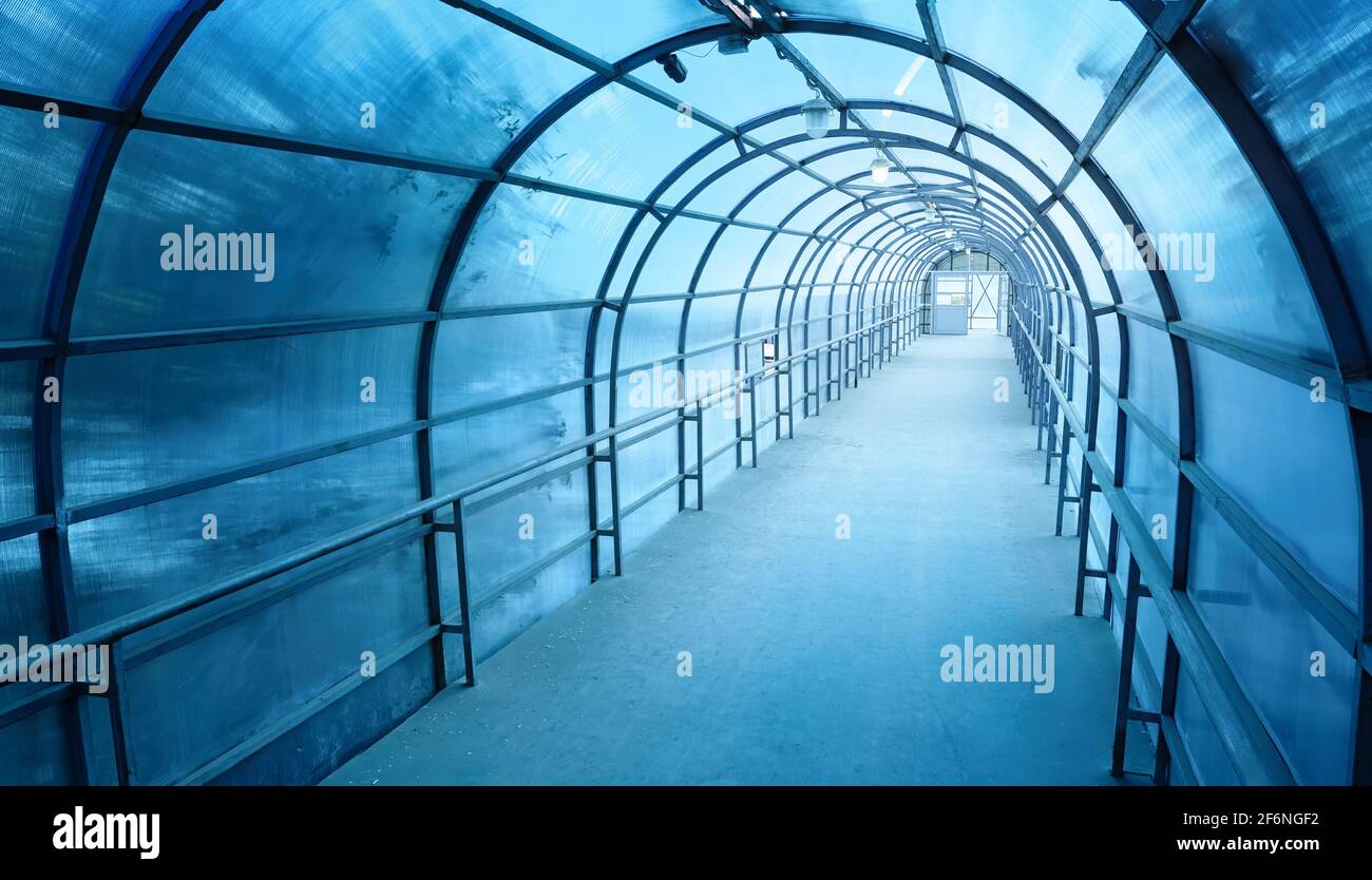 Tunnel di stile industriale blu con ombre sulle pareti e. la luce alla fine di esso Foto Stock