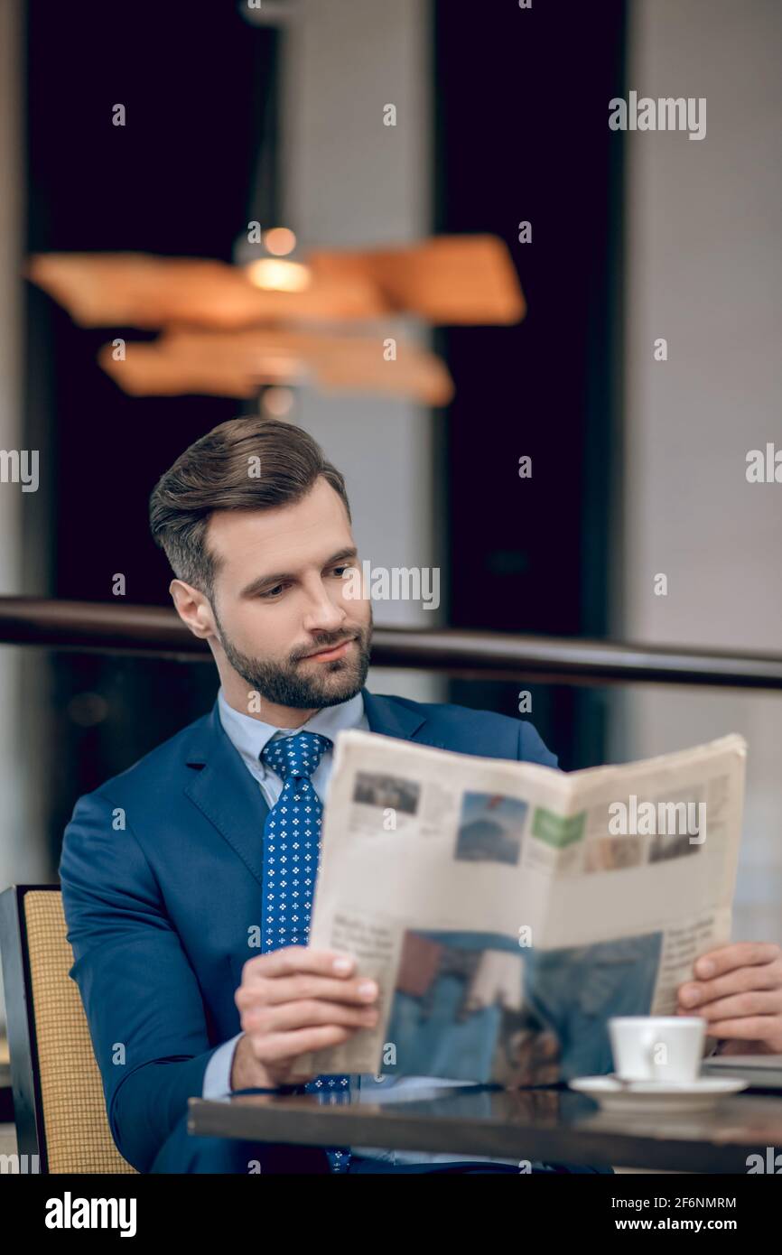 Notizie del mattino. Uomo d'affari elegante in un bel vestito che legge un giornale del mattino Foto Stock