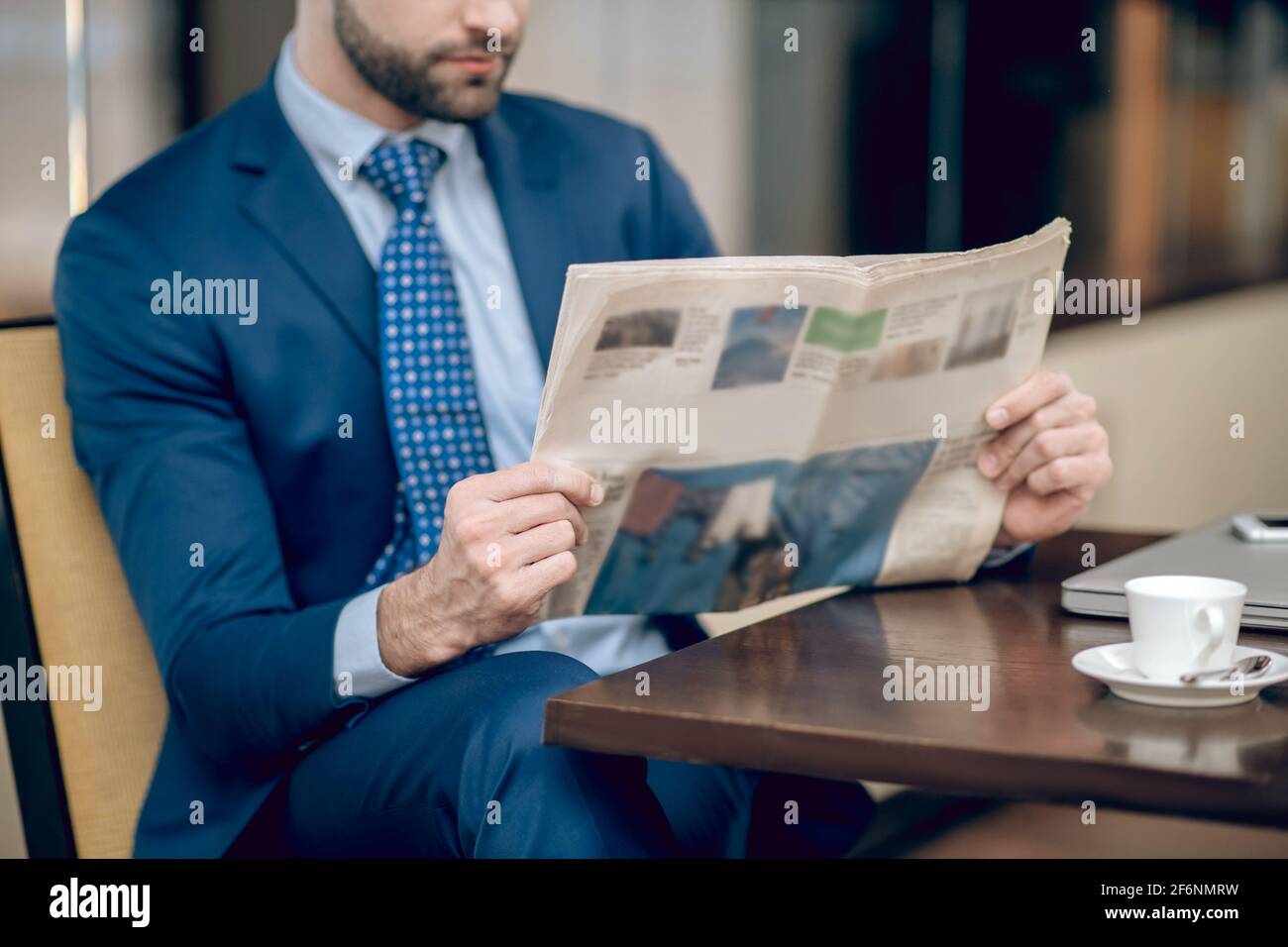 Notizie del mattino. Uomo d'affari elegante in un bel vestito che legge un giornale del mattino Foto Stock