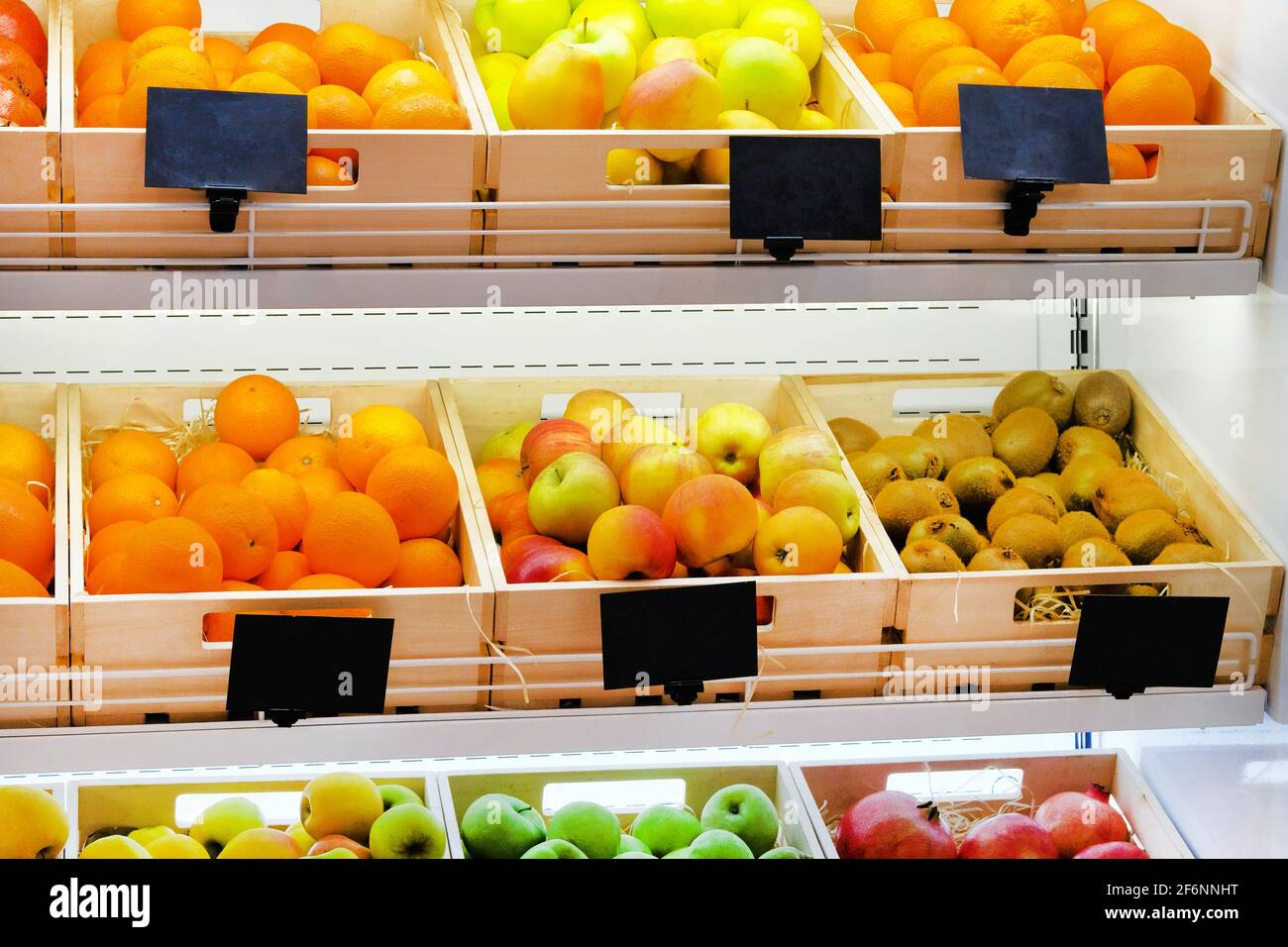 Varietà di frutta diverse arance, kiwi, mele, melograni sugli scaffali del supermercato. Vitamine e minerali. Foto Stock