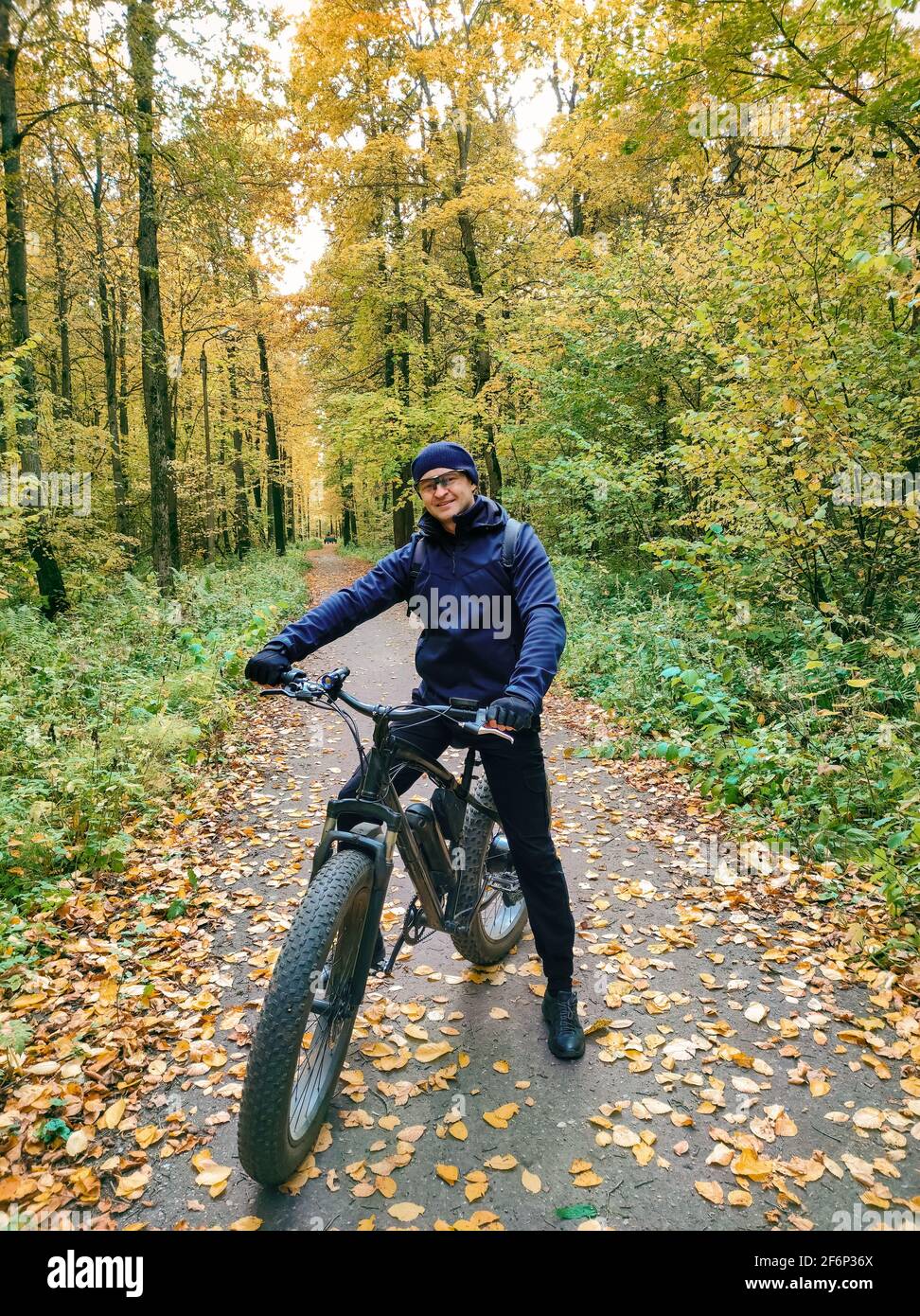 Un uomo sportivo su una bici elettrica grasso nel bosco. Super