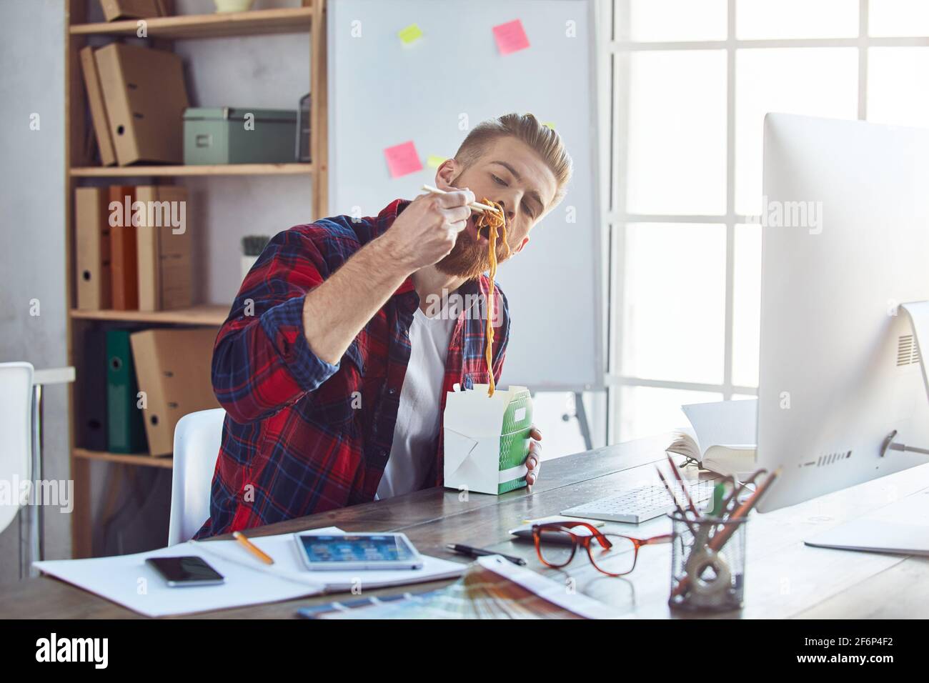 Lavoratore in ufficio che ha una pausa pranzo mentre si trova in studio creativo Foto Stock