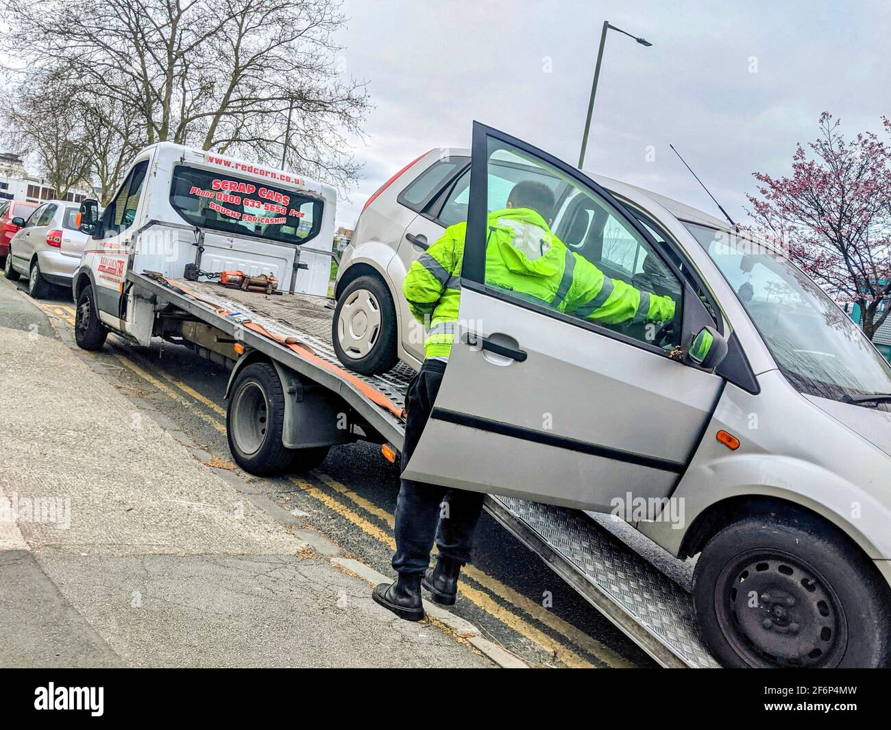Un vecchio Ford Fiesta d'argento, rotto, essendo fissato ad un veicolo di rimozione che è stato venduto per metallo di scarto a Redcorn Ltd, Londra. Foto Stock