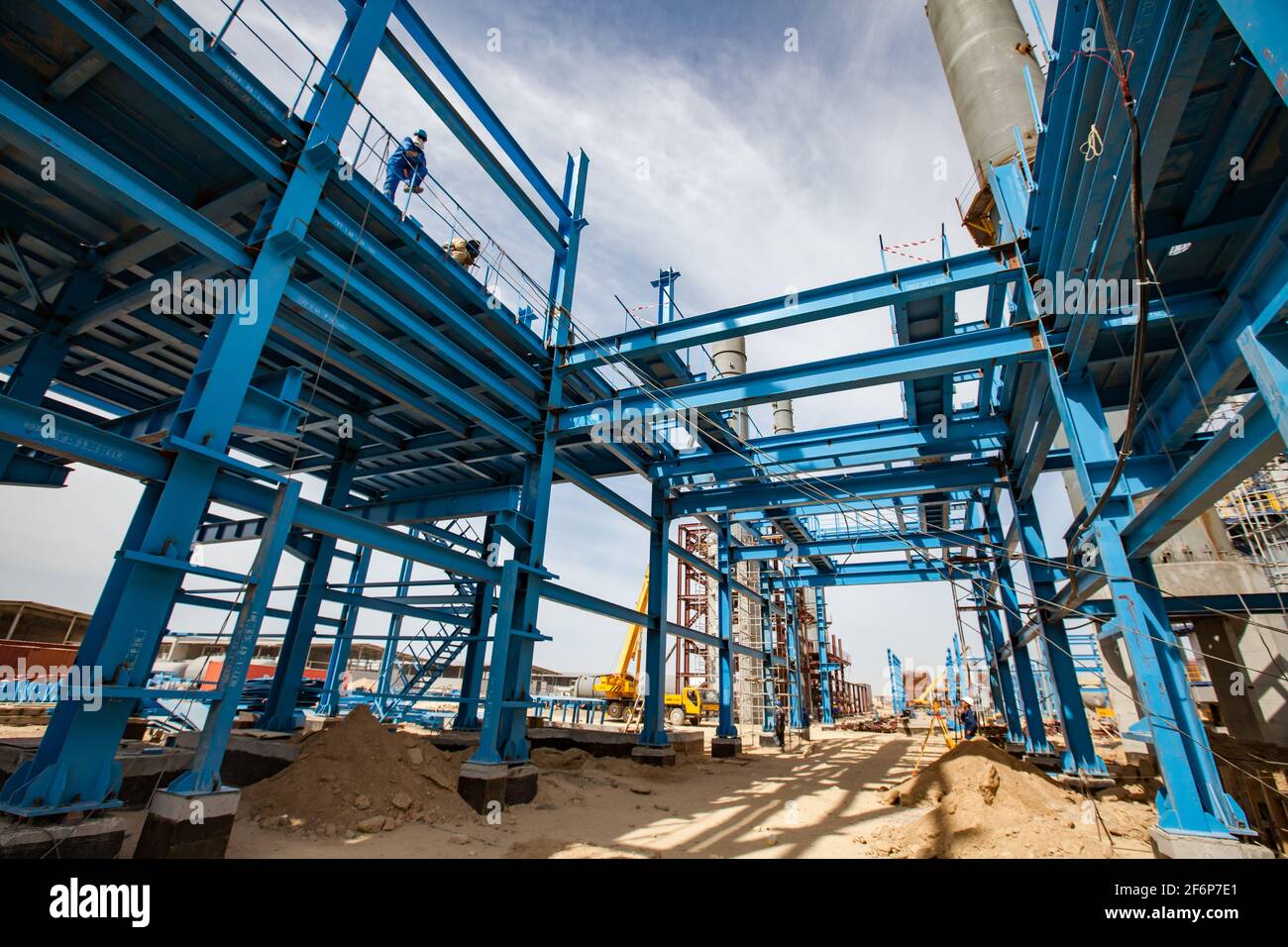 Aktau, Kazakhstan - 19 maggio 2012 costruzione di un moderno impianto di bitume asfaltico. Struttura in acciaio blu, torri di distillazione grigie, gru gialla Foto Stock