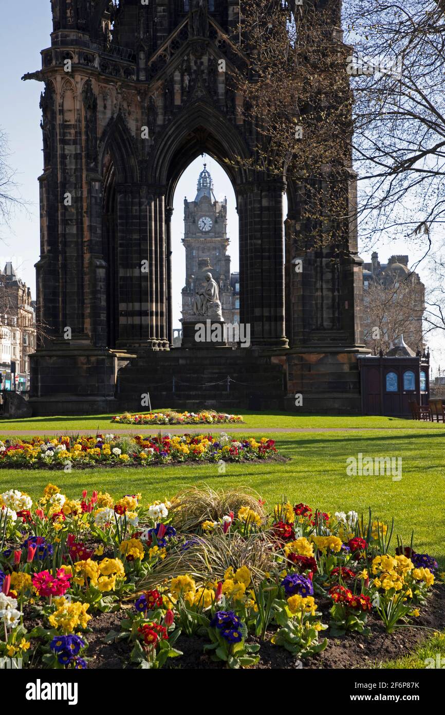 Centro di Edimburgo, Scozia, tempo del Regno Unito. 2 aprile 2021. Sole in tranquillo centro città per Pasqua Venerdì Bank Holiday, temperatura 9 gradi centigradi. Nella foto: Giardini di Princes Street East colorati aiuole primaverili con Scott Monument e Torre dell'Orologio Baloral in background. Foto Stock