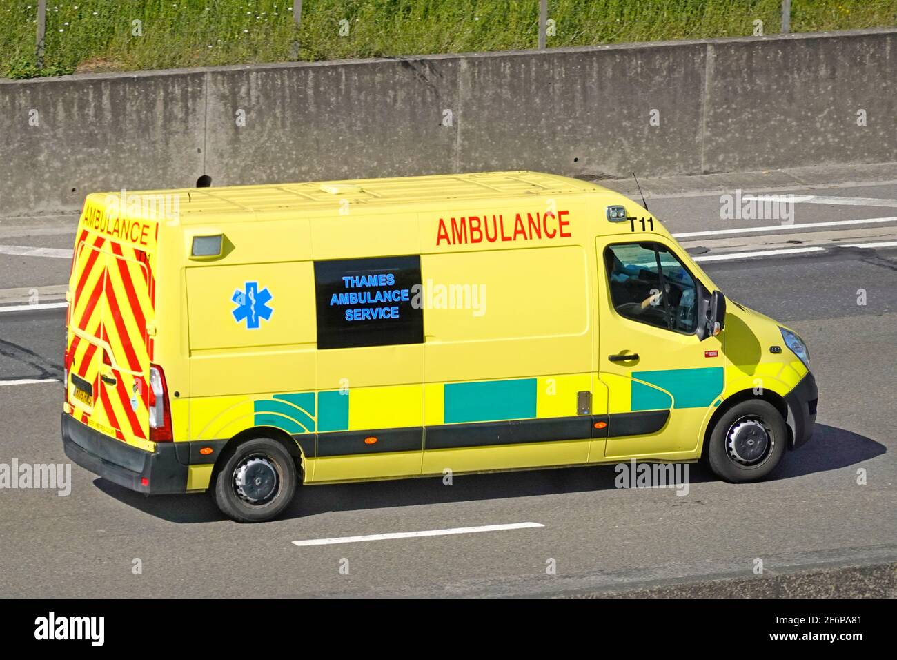 Vista laterale e posteriore del servizio di trasporto paziente Thames Ambulance veicolo e conducente forniti da un'azienda sanitaria privata che guida lungo Autostrada del Regno Unito Foto Stock