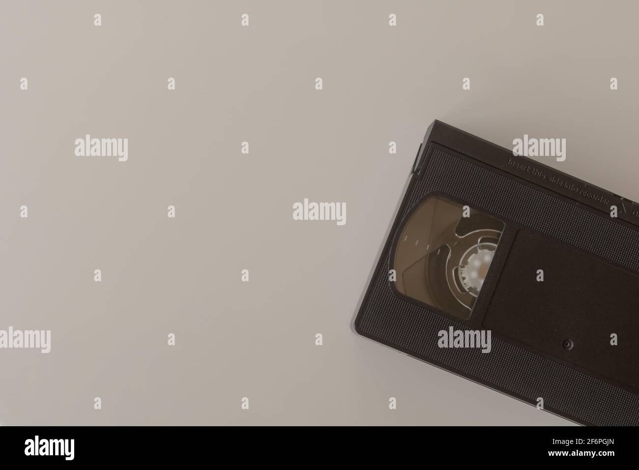 Vecchio nastro VHS Video nero, cassetta su sfondo bianco, posa piana. I nastri VHS utilizzati per la riproduzione di film e filmati hanno raggiunto il picco negli anni '90 Foto Stock