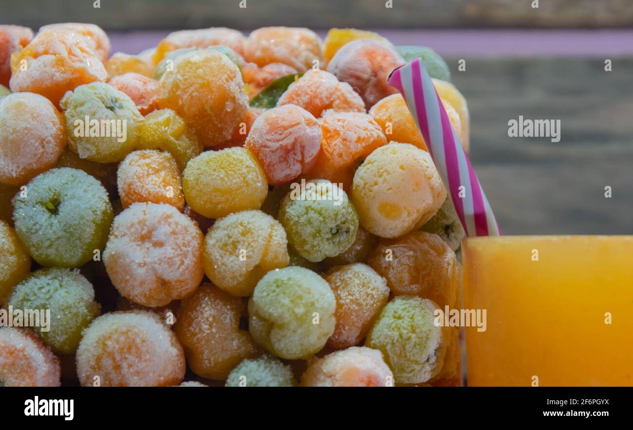 Succo di Acerola (emarginata di Malpighia) e frutta fresca di acerola surgelata. Fonte di succo di antiossidanti, come è il secondo frutto con il più alto contenuto Foto Stock