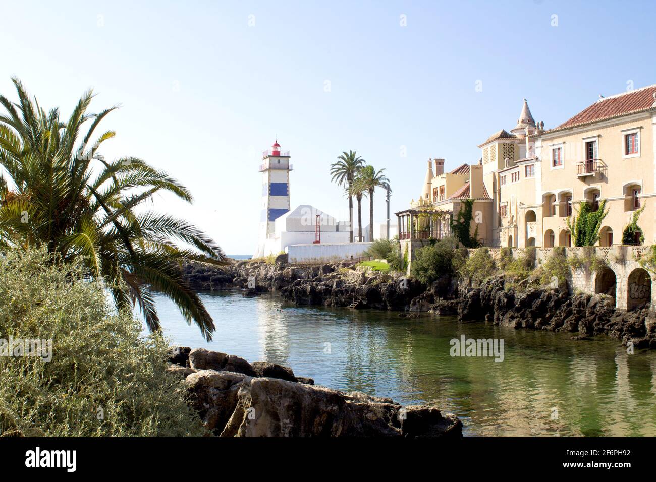 Splendida vista sulla spiaggia, il faro e la villa durante il giorno di sole. Cascais. Portogallo. Foto Stock