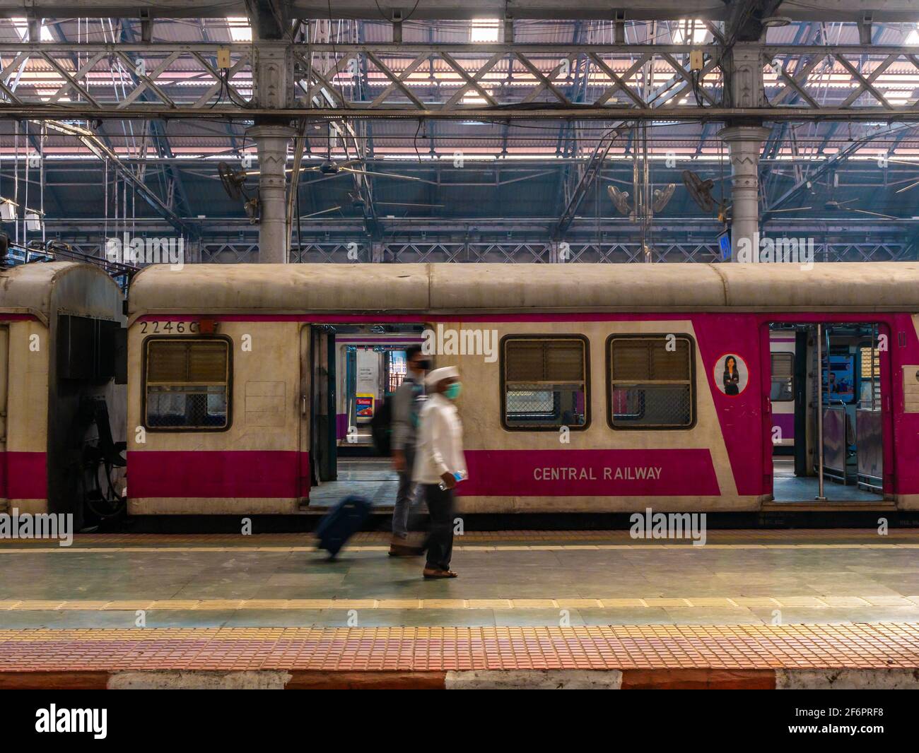 Mumbai, India - 7 gennaio 2021 : passeggeri non identificati (volti sfocati) che camminano su un binario alla stazione CST, una delle stazioni ferroviarie più trafficate per Foto Stock