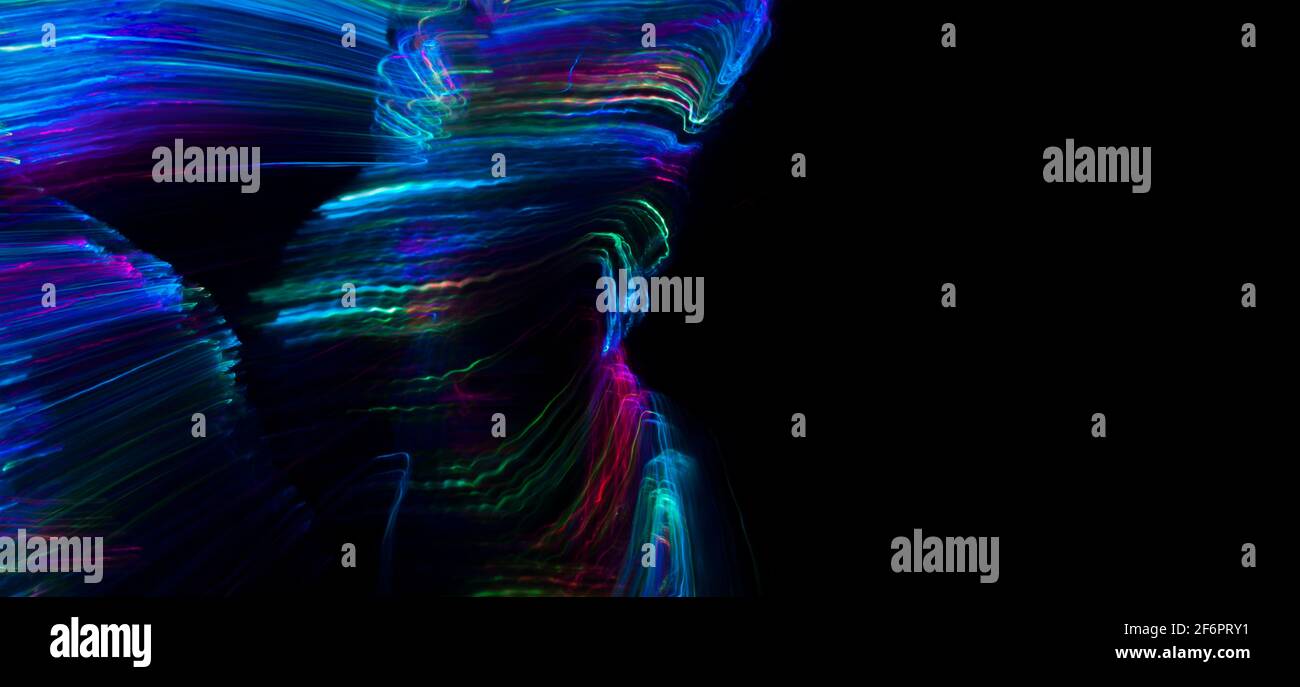 sottili linee di luce multicolore curve in forma arbitraria, su sfondo nero Foto Stock