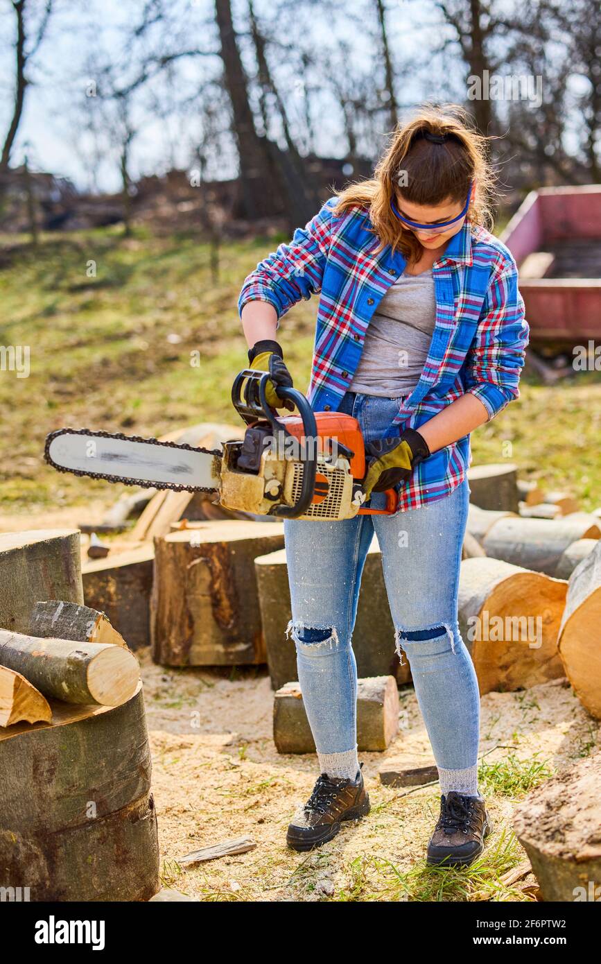 Giovane Donna con motosega per tagliare un log per legna da ardere Foto  stock - Alamy