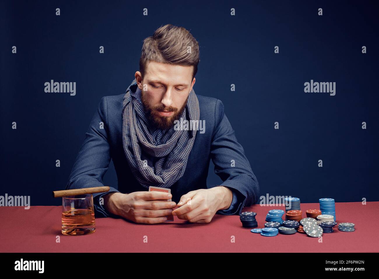 Elegante uomo bearded che gioca nel casinò scuro Foto Stock