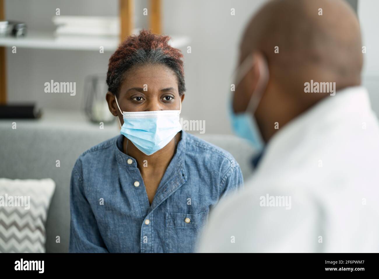 Cura del medico e paziente in maschera di gente di Covid Foto Stock