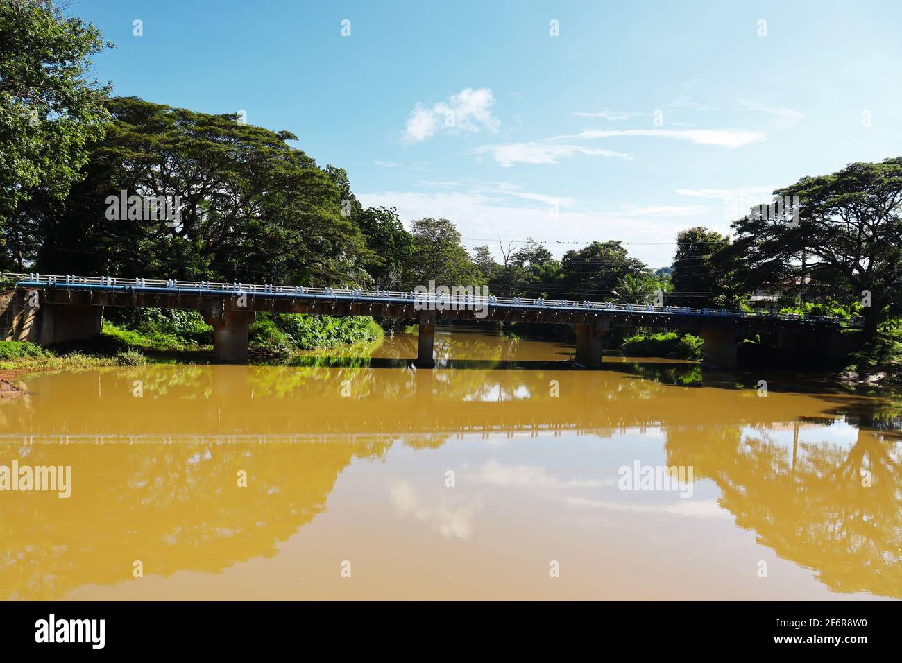 un ponte di cemento sul fiume di fango Foto Stock