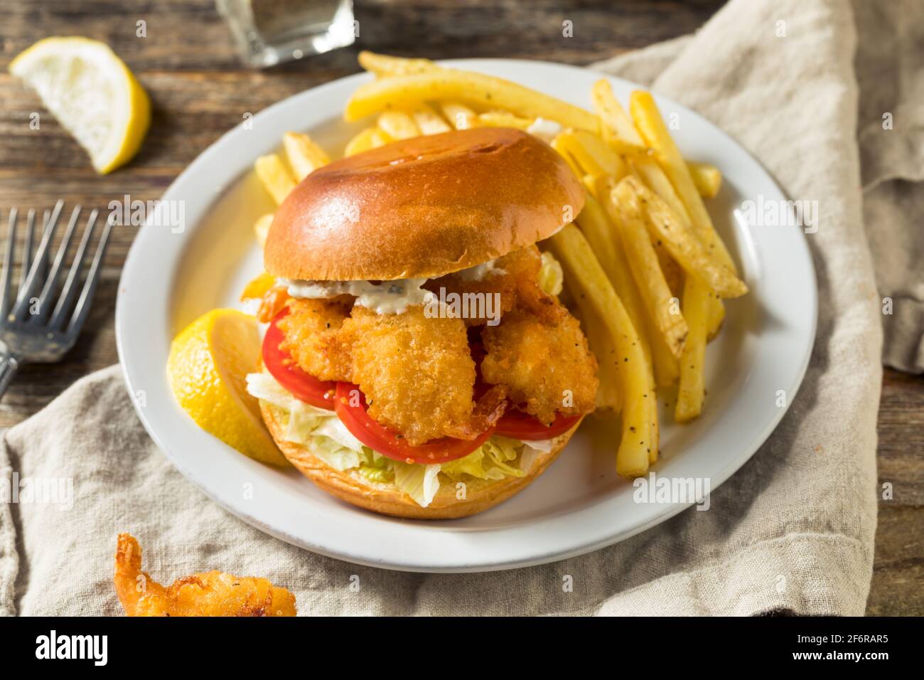 Sandwich di gamberi fritti fatti in casa con coleslaw e patatine fritte Foto Stock