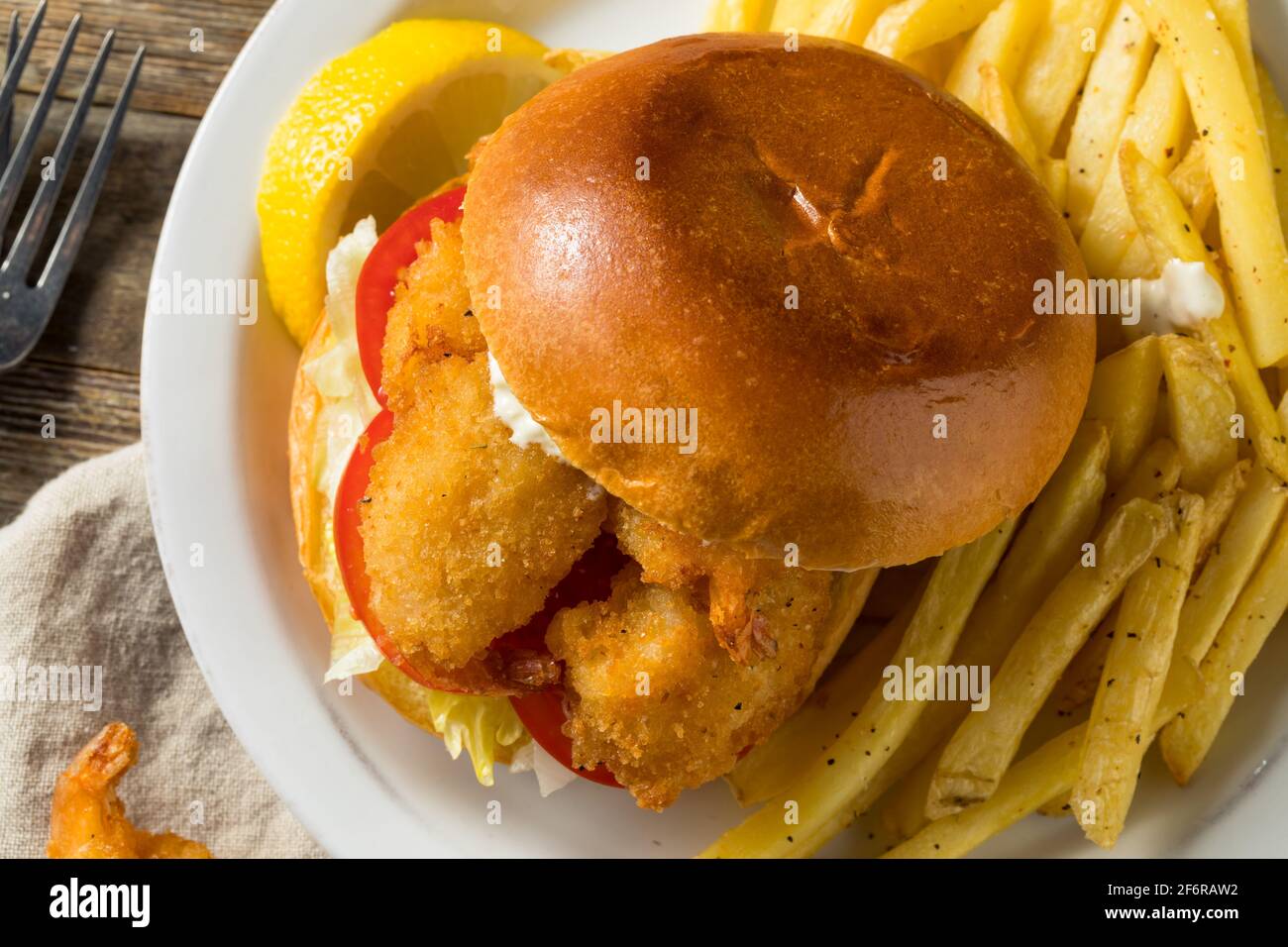 Sandwich di gamberi fritti fatti in casa con coleslaw e patatine fritte Foto Stock
