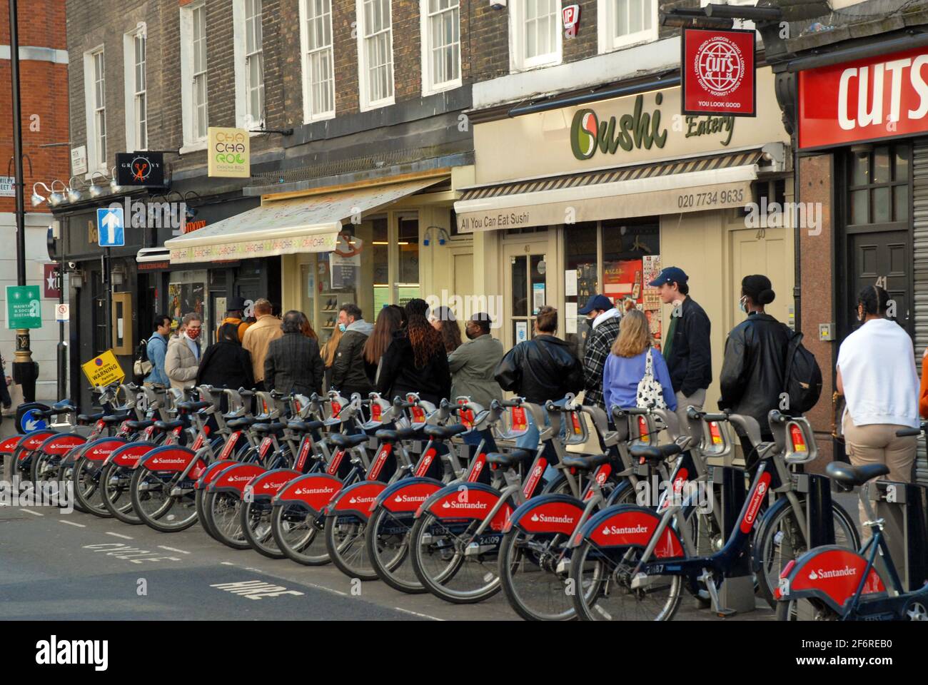 Londra, Regno Unito, 2 aprile 2021 coda al Cha Cha Roll per prendere un'astata a Soho. La gente gode del sole nel West End il Venerdì Santo mentre le restrizioni di blocco del coronavirus cominciano ad essere tolte. Credit: JOHNNY ARMSTEAD/Alamy Live News Foto Stock