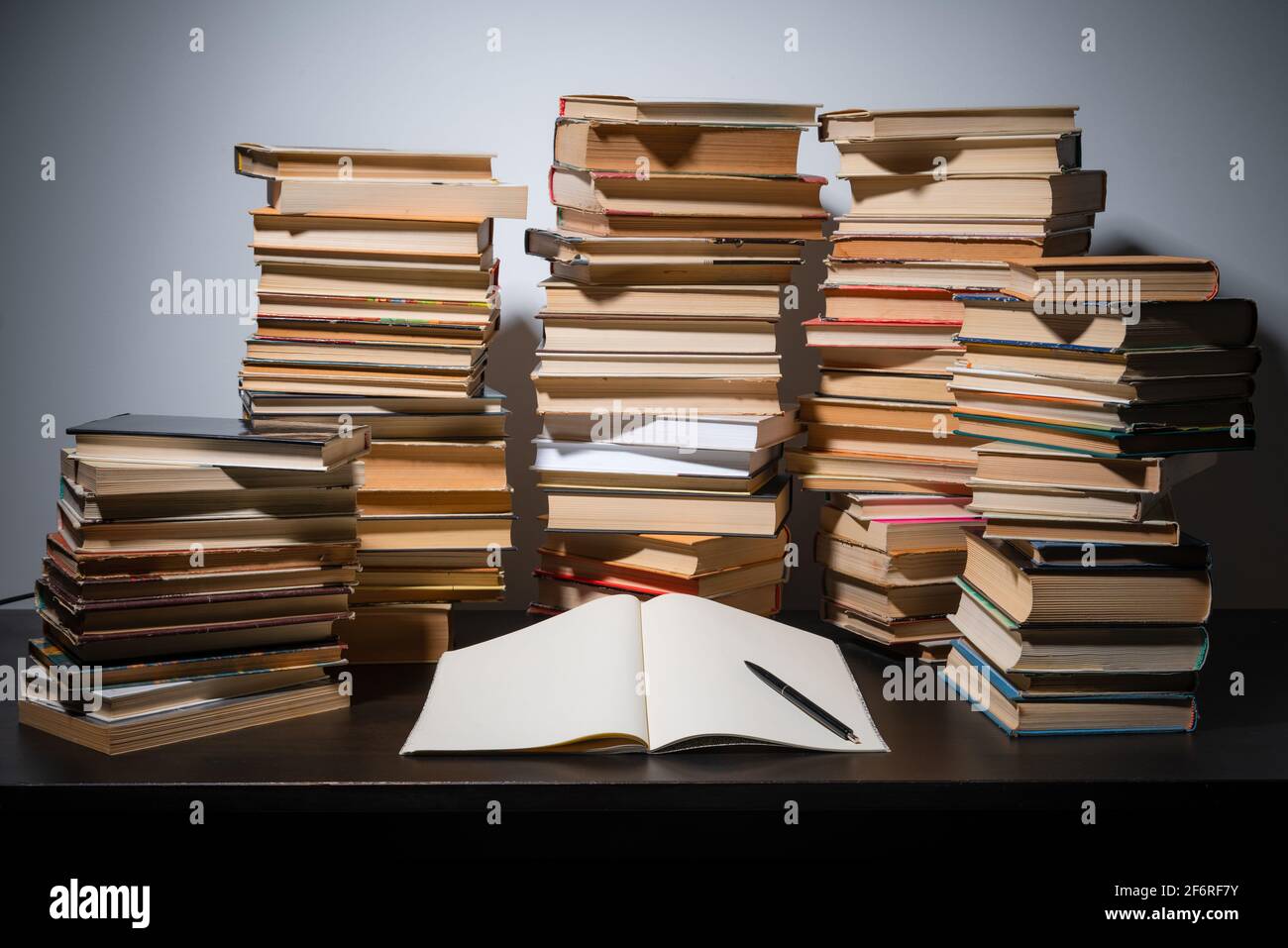 Grande pila di libri sul tavolo. Studiare prima dell'esame. Pila di libri d'epoca. Concetto di istruzione e di studio Foto Stock