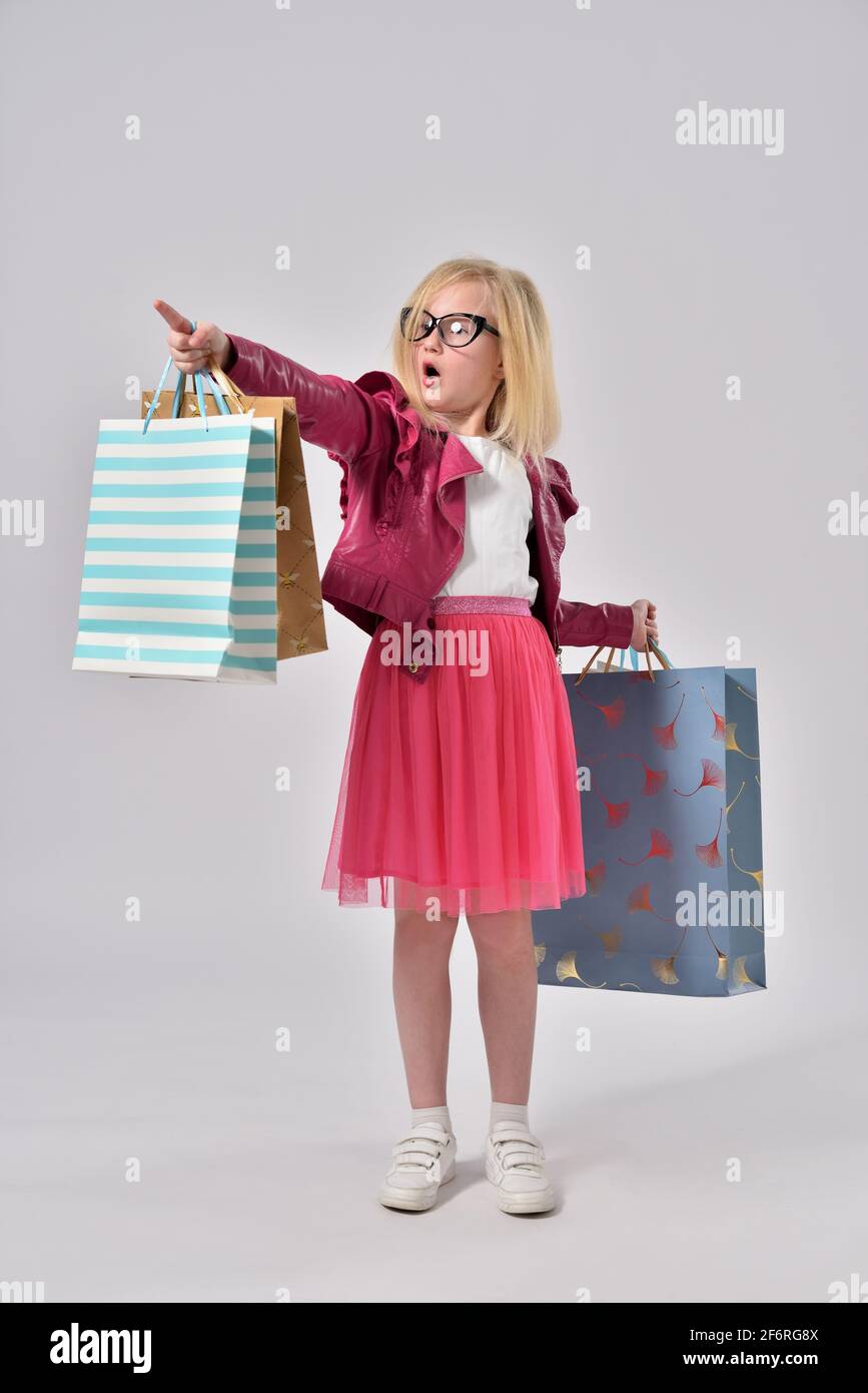 La ragazza adolescente vuole comprare più cose mentre lo shopping e punta il suo dito. Foto Stock