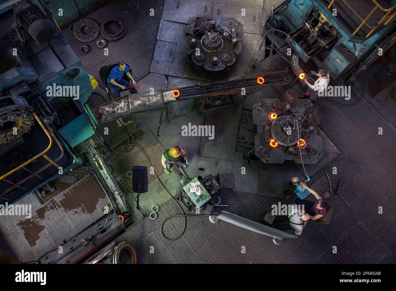 Stepnogorsk, Kazakhstan 04 aprile 2012: Laboratorio di produzione di cuscinetti. Produzione di parti di cuscinetti della pista esterna rossa-calda sul trasportatore. Operatori a Foto Stock