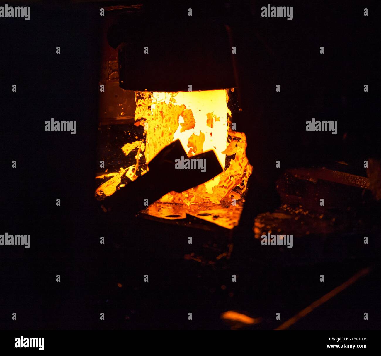 Macchina di pressatura (punzonatura). Parti cuscinetto pista esterna di produzione. Metallo rosso-caldo con strisce di scorie. Foto Stock