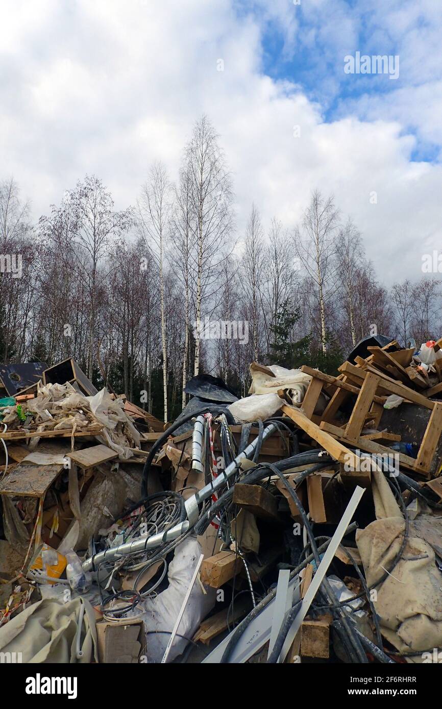 Un mucchio grande di rifiuti nella foresta. Cumulo di detriti di costruzione e rifiuti nella foresta. Ecologia e inquinamento ambientale. Foto Stock