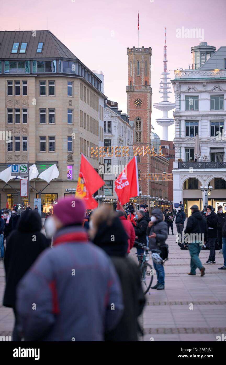 Amburgo, Germania. 02 aprile 2021. I partecipanti al rally si trovano sul Rathausmarkt di fronte alla torre della televisione e sul muro di Neuer al tramonto. Poco prima della prima entrata in vigore di un coprifuoco notturno ad Amburgo, i gruppi di sinistra hanno dimostrato al Rathausmarkt contro la politica di Corona del Senato. Credit: Jonas Walzberg/dpa/Alamy Live News Foto Stock