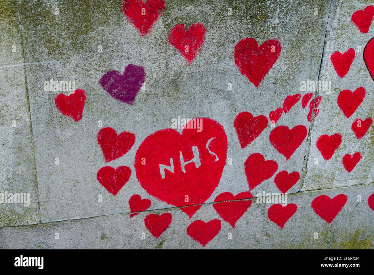 NHS scritto all'interno di un cuore rosso sulla parete commemorativa del Covid nazionale, la riva sud di Londra, sull'Embankment, Inghilterra Foto Stock