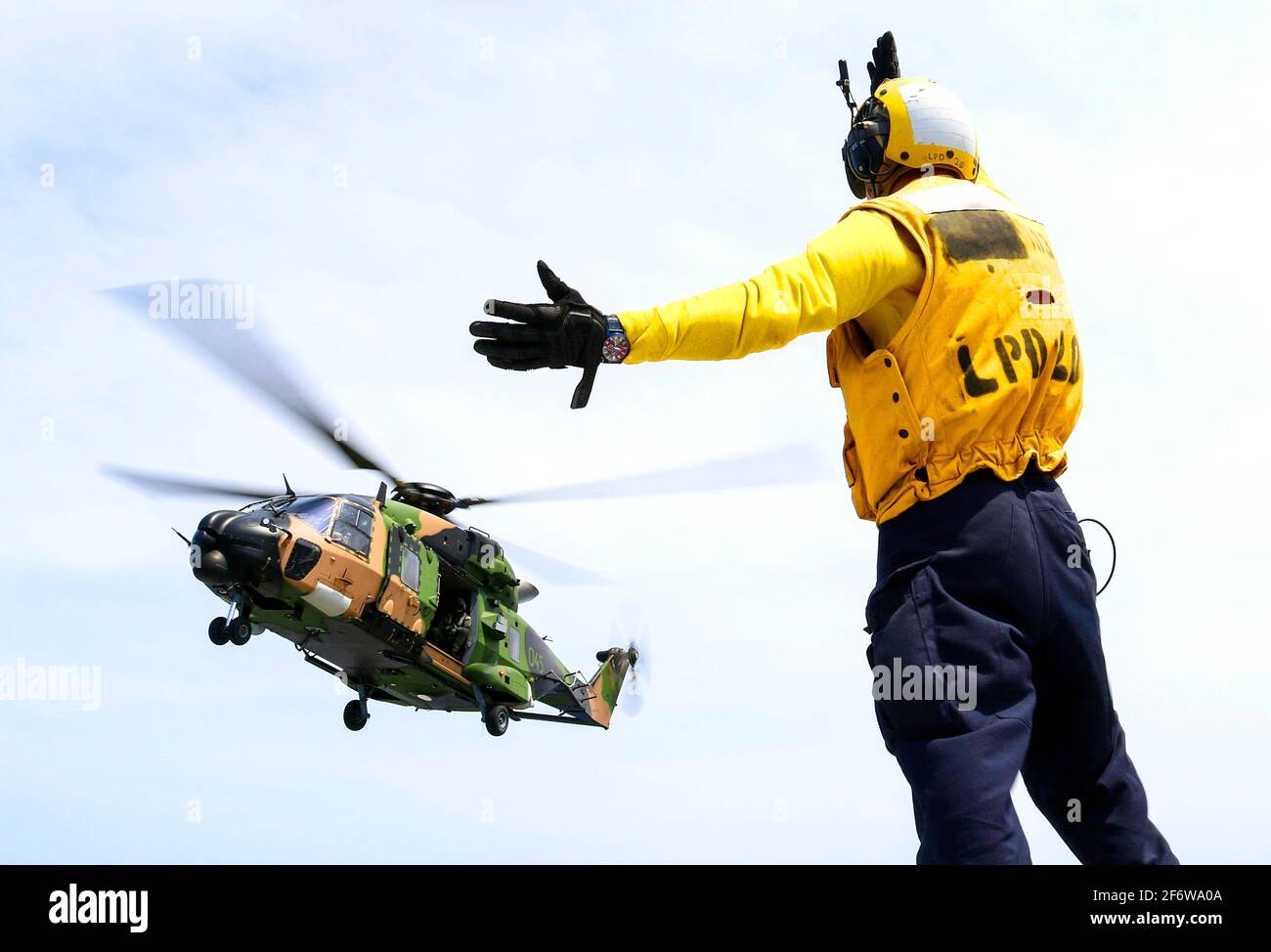 CORAL SEA (Nov. 19, 2018) Aviation Boatswainâ.s Mate (Handling) Airman Caleb Brawner, da Wichita, Kan. , segnala un elicottero MRH-90 Taipan Foto Stock