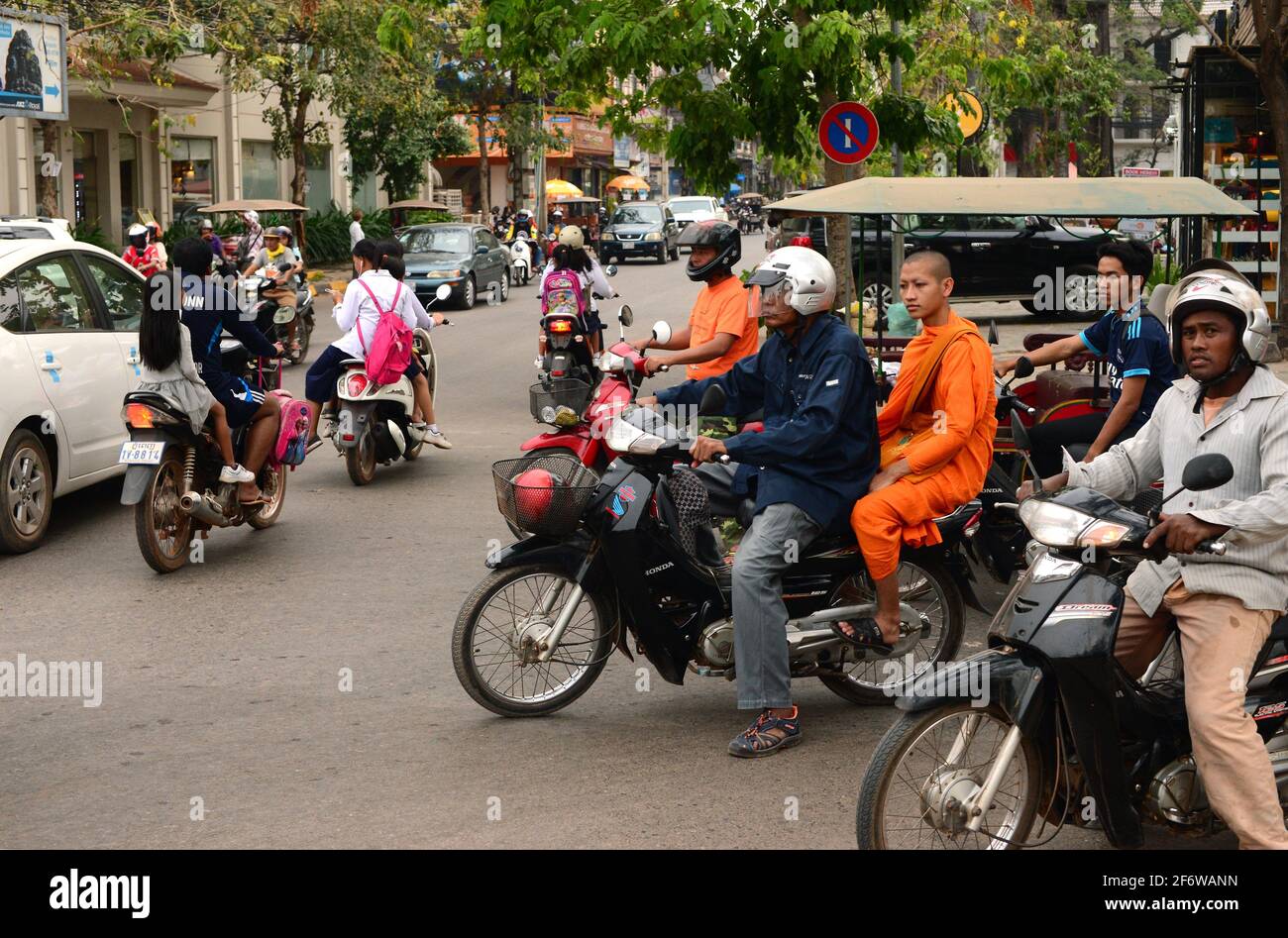 Siem Reap città. Strada con auto, moto e rickshaw auto o tuk-tuk. Cambogia. Foto Stock