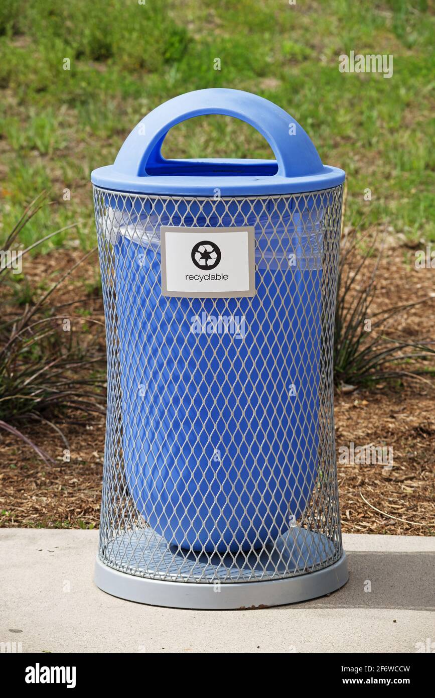 contenitore per la raccolta del riciclaggio di plastica e metallo blu in un parco Foto Stock