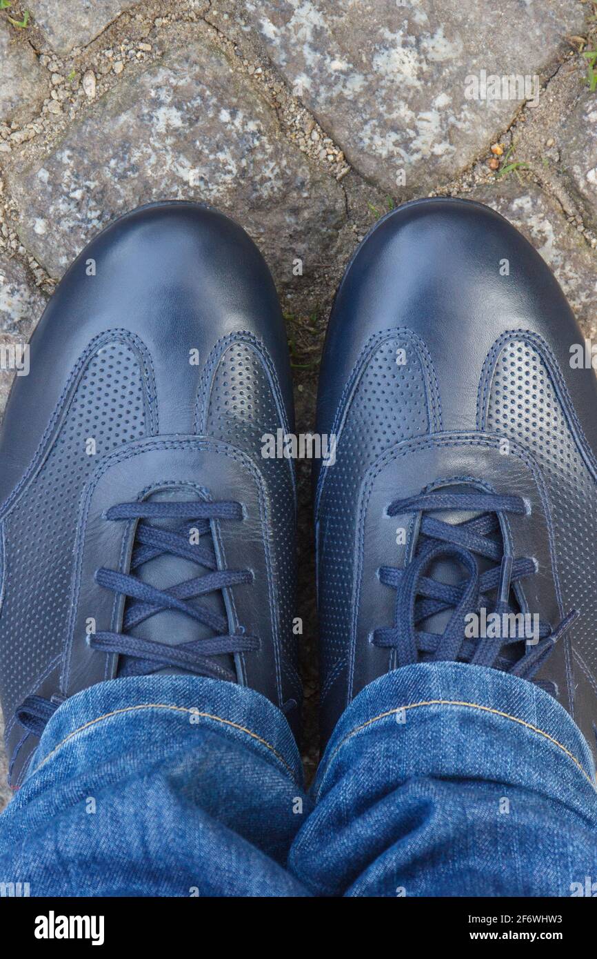 Comode scarpe casual casual in pelle blu navy per uomo su strada o sentiero  fatto di rocce o pietre. Calzature maschili Foto stock - Alamy