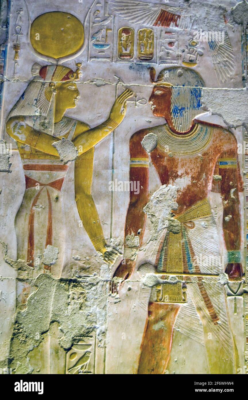 Antica scultura geroglifica egiziana della dea Hathor con una caviglia davanti al Faroah Seti I. scultura colorata su una parete del Tempio di Abydos Foto Stock