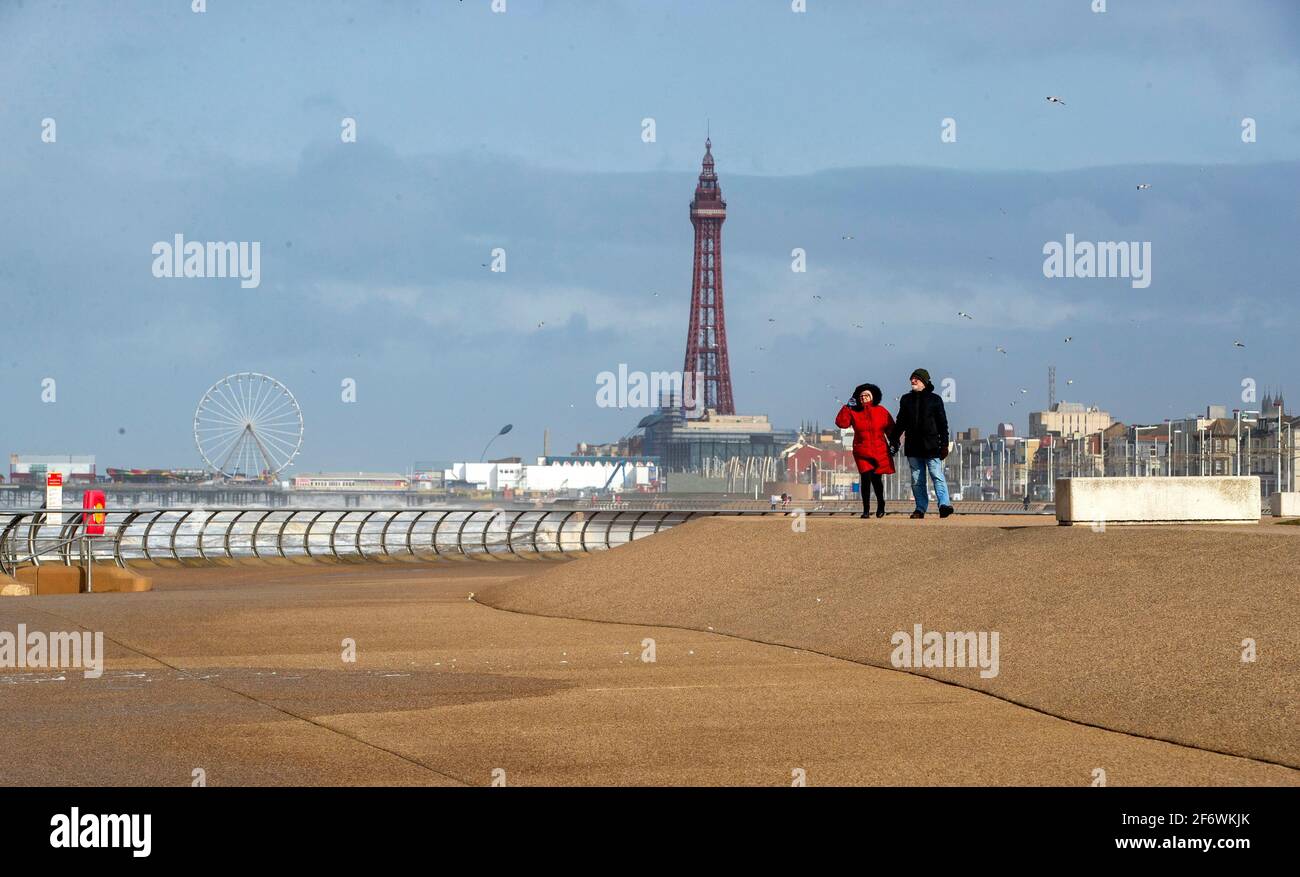 File foto datata 11/03/21 di un uomo e di una donna camminano lungo la passeggiata a Blackpool. Le imprese di staycation stanno segnalando "una domanda enorme" per la loro riapertura prevista il 12 aprile. Data di emissione: Sabato 3 aprile 2021. Foto Stock