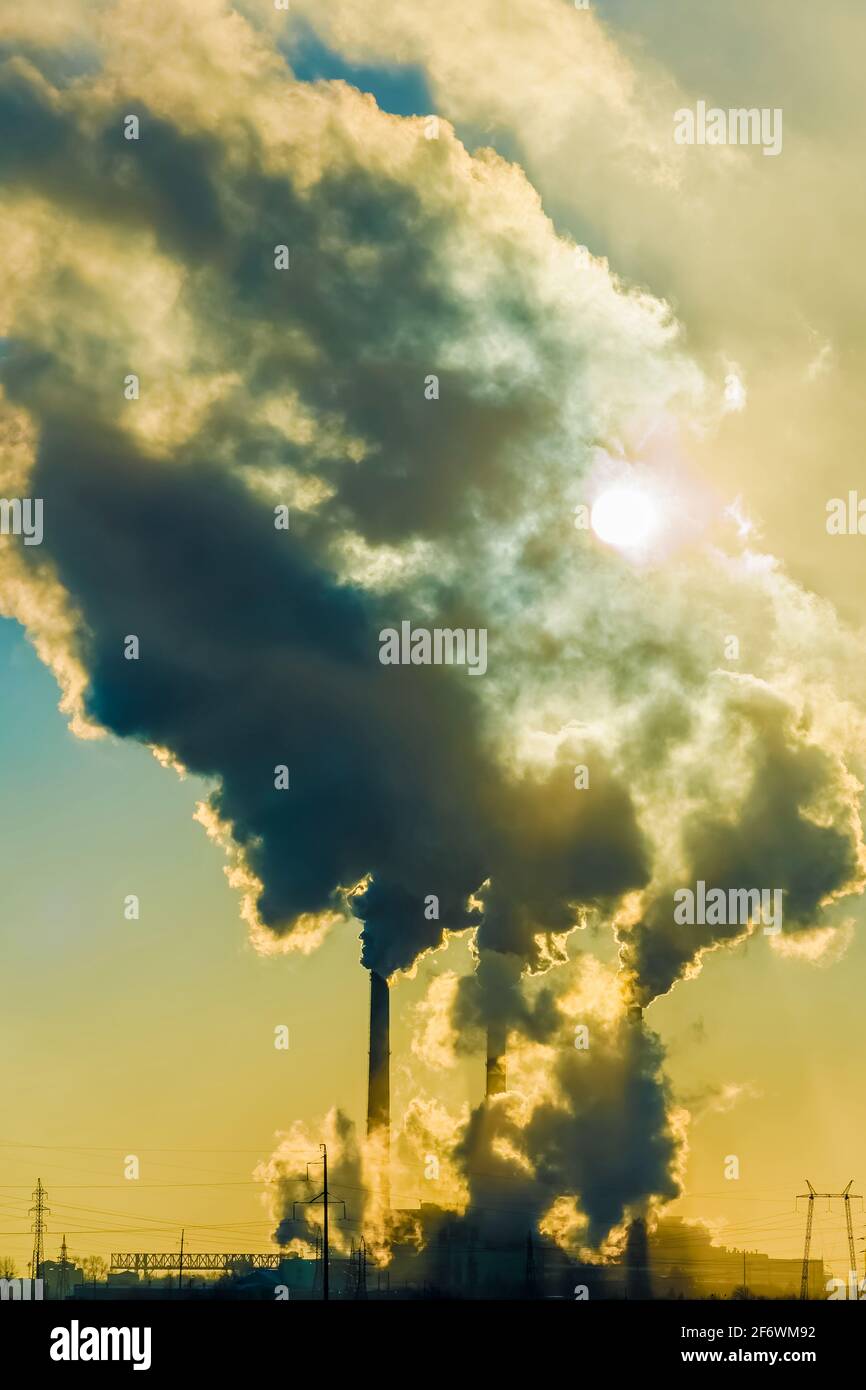 Tramonto sulla città industriale. Camini di fabbrica fumo. Problema ambientale di ambiente E inquinamento atmosferico. Cambiamento climatico, ambientale d Foto Stock