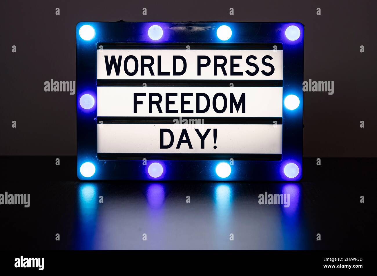 Scatola luminosa con luci blu in camera oscura con parole - giornata mondiale della libertà di stampa! Foto Stock