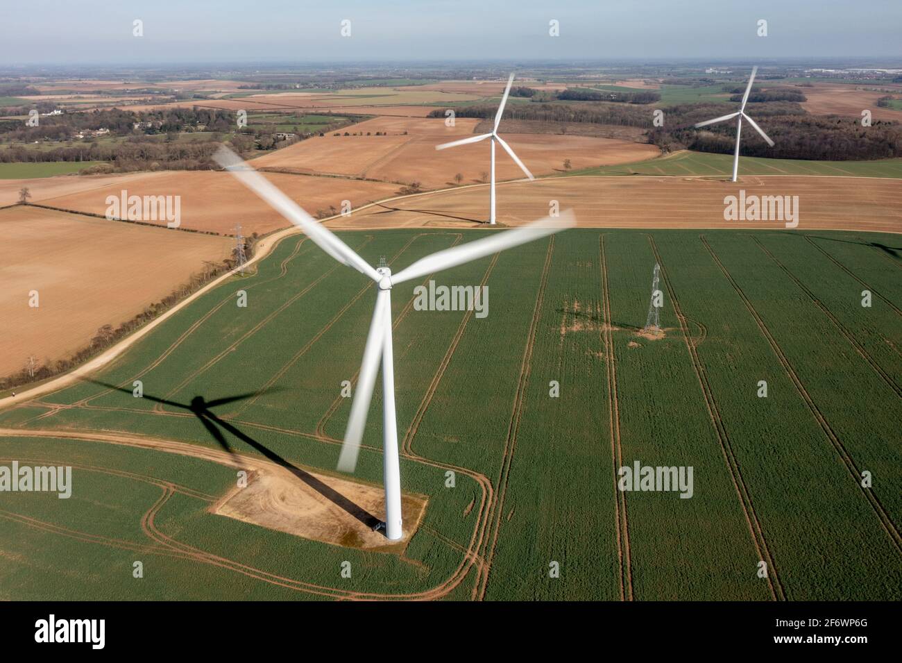 Turbi eolici che generano elettricità rinnovabile, rappresentando energia pulita, produzione di energia sostenibile e la transizione lontano dai combustibili fossili. Foto Stock