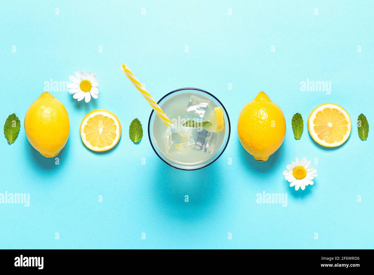 Vista dall'alto di limonata e fette di limone su sfondo blu con copyspace. Foto Stock