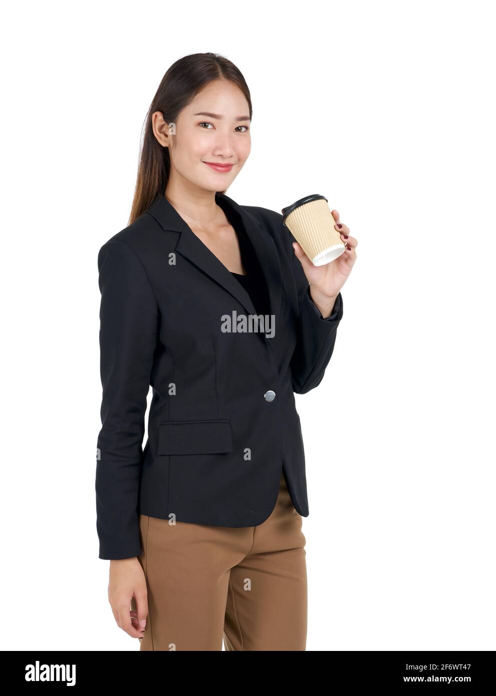 Giovani donne asiatiche in tuta nera con un sorriso che tiene una tazza di caffè. Ritratto su sfondo bianco con luce da studio. Foto Stock